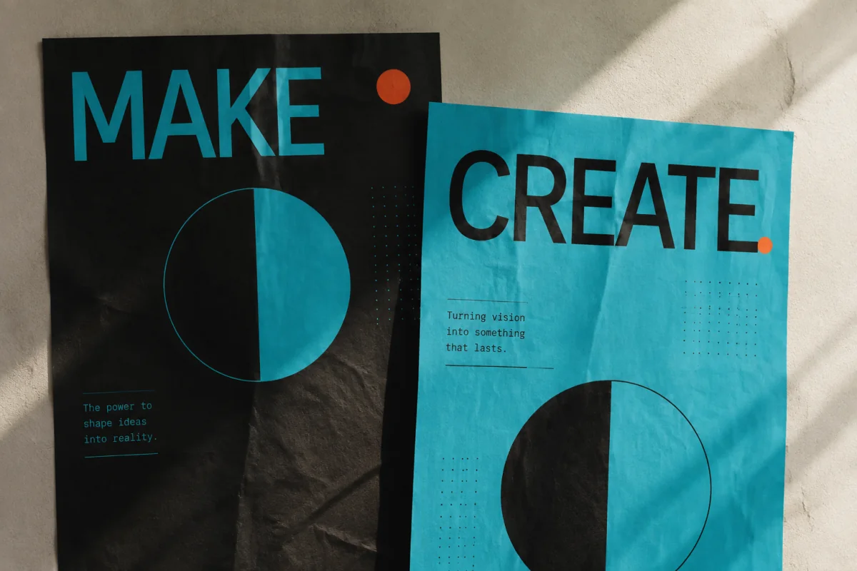 Cyan and black MAKE and CREATE posters with orange accents on a textured wall.